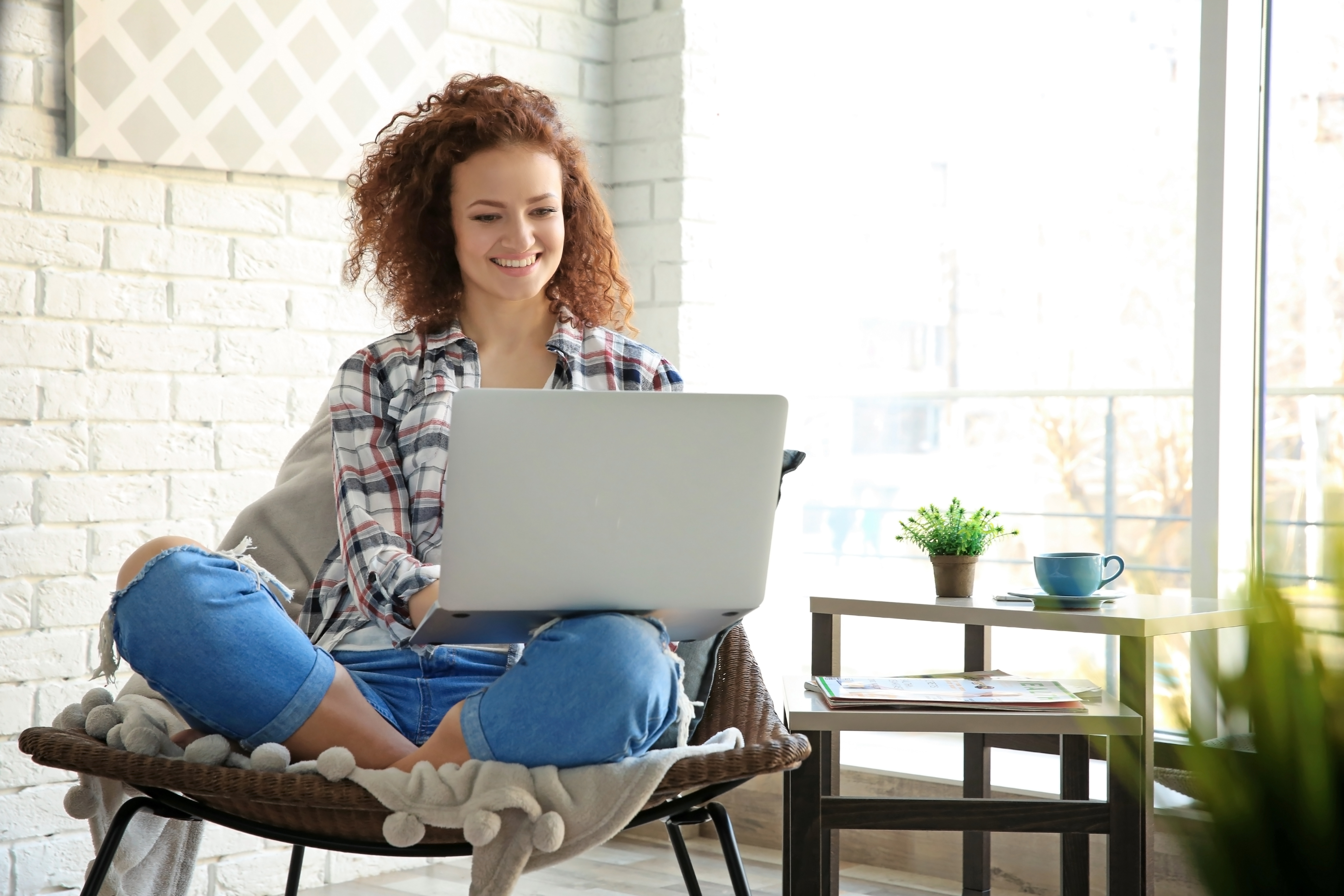 A woman sits on her laptop managing her credit union account.